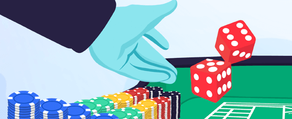 hand throwing dice at casino table with chips